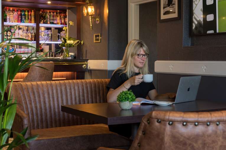 Devon Hotel carriages bar and brasserie bar woman on laptop drinking coffee business