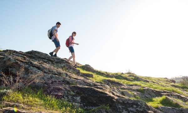 A couple walking down a rocky hill on a countryside hike