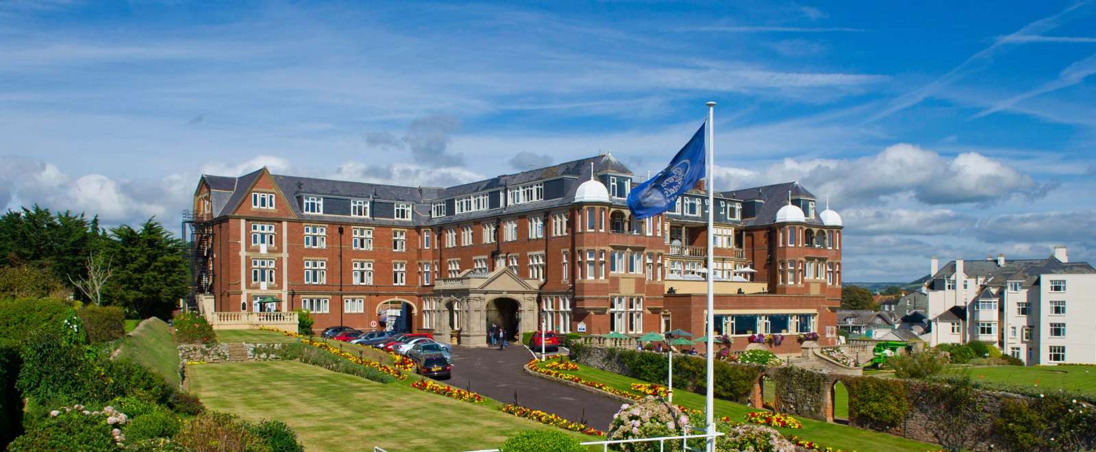 Victoria Hotel External View with Flag and Gardens