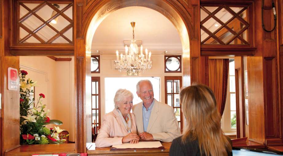 Belmont Hotel Happy Guests Arriving at Reception Desk