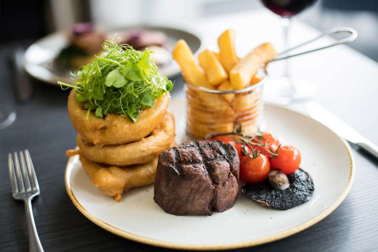 Park Hotel Restaurant Dining Beef with Onion Rings Chips Mushroom and Vine Tomatoes
