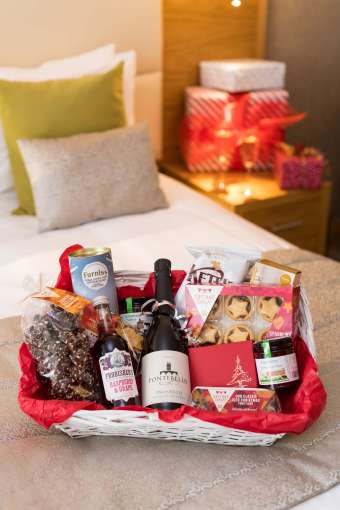 Park Hotel Festive Christmas Hamper on Bed in Room with Presents and Prosecco