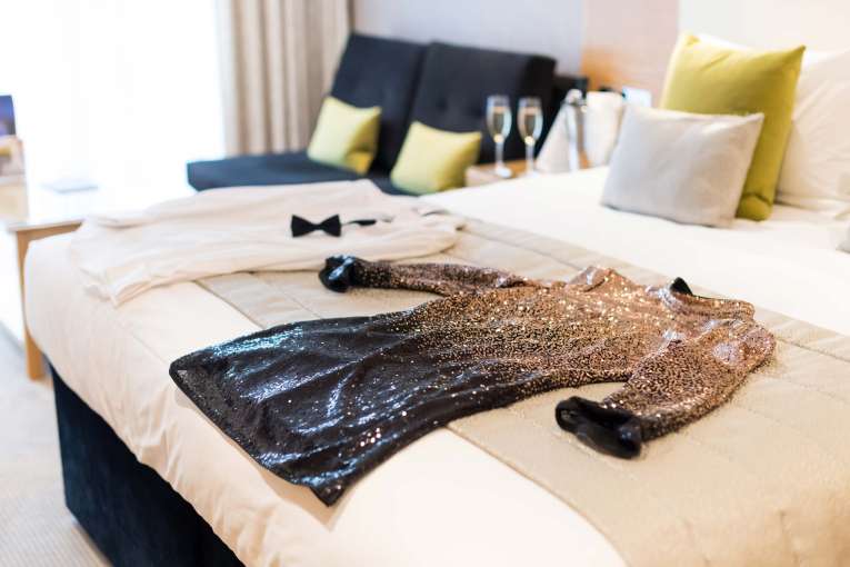 Park Hotel Christmas Party Outfits on Bed with Champagne on Table