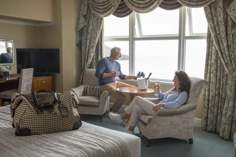 Royal Duchy Hotel Couple Enjoying View from Bedroom Window with Champagne