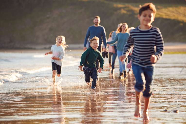 A large family walking and running along the beach
