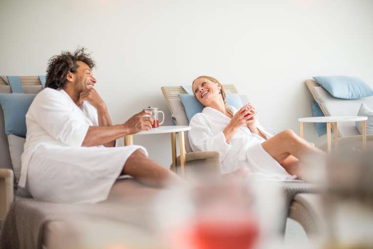 couple drinking herbal tea sat on loungers in relaxation room in source spa