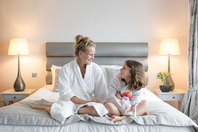 mother and daughter sat on end of bed AT Saunton Sands hotel