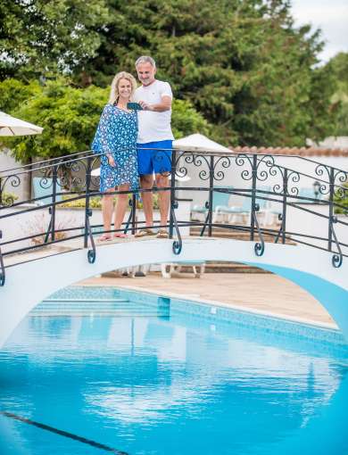 couple stood on bridge over the outdoor pool at the Victoria Hotel 