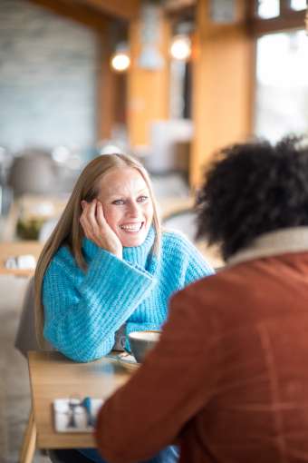 couple sat at table in beachside grill woman smiling at man
