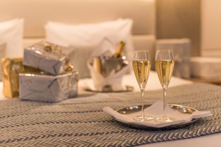 christmas presents and champagne on bed at Carlyon Bay Hotel