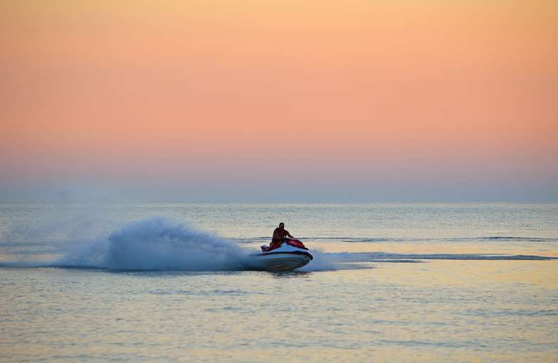 Jet ski on sea at sunset