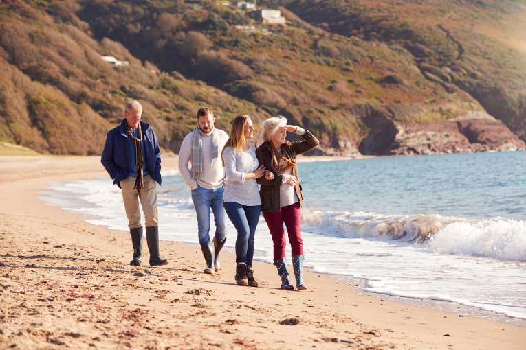 4 adults on a beach in autumn