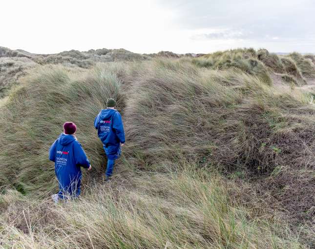 Couple walking along Saunton sand dunes