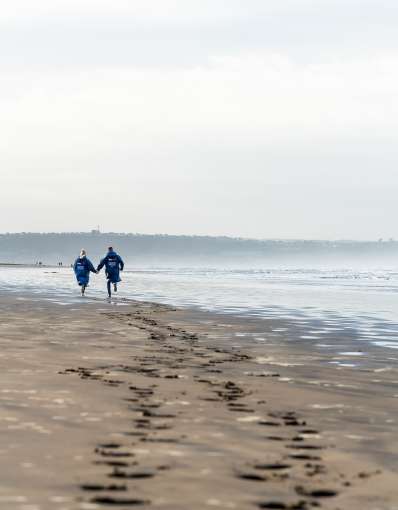 Couple walking along Saunton Sands 