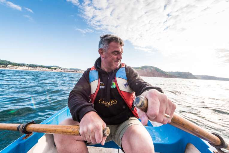 Matthew Raistrick rowing a boat at sea