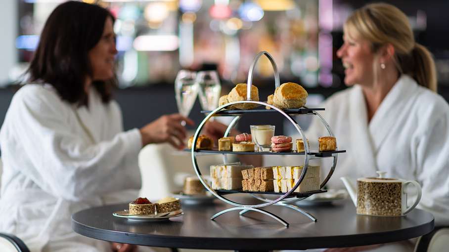Women enjoying an Afternoon Tea with a pot of tea and glass of prosecco 