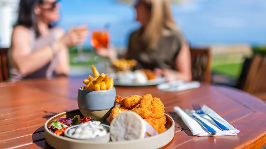 Two woman dining alfresco with drinks on the terrace