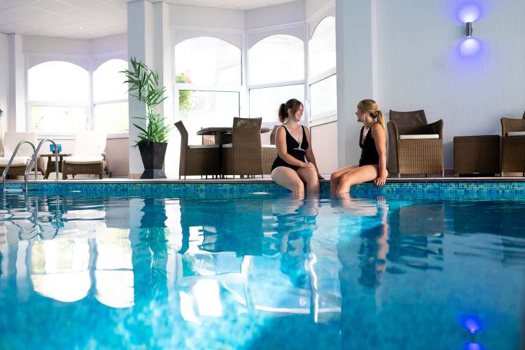 two ladies sitting by the indoor pool at The Royal Duchy Hotel