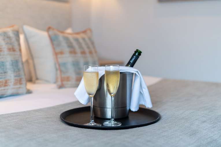 Bottle and two glasses of Champagne on the bed at The Royal Duchy Hotel