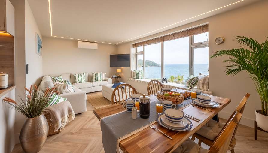 The Duchy Beach House Living Room with table set up for breakfast