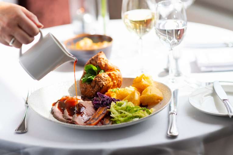 Person pouring gravy on a roast at The Royal Duchy Hotel 