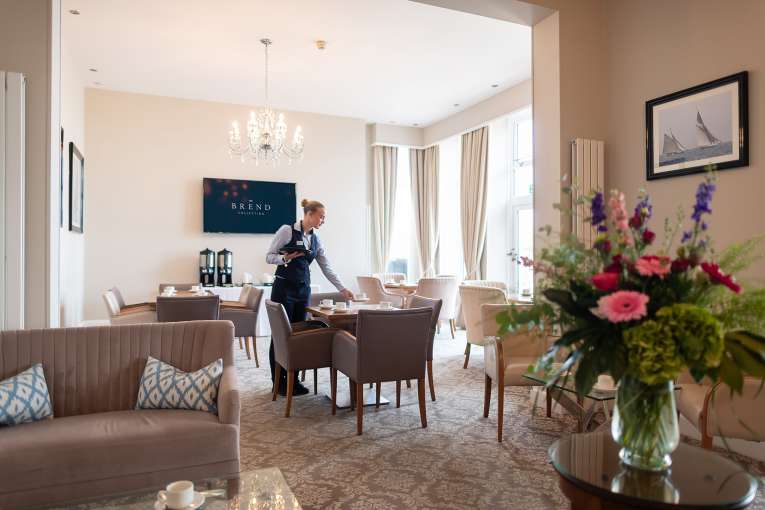 Waitress setting up table in the terrace lounge at The Royal Duchy Hotel 