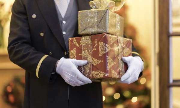 Belmont Hotel Doorman Holding Christmas Presents