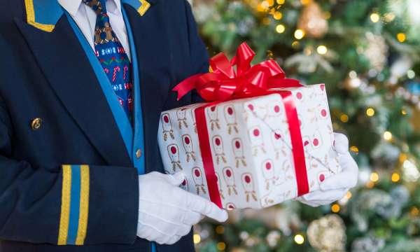 Royal Duchy Hotel Doorman with Festive Tie Holding Christmas Present