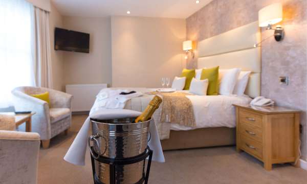 Royal and Fortescue Hotel Christmas Party Outfits on Bed in Room with Champagne in Ice Bucket