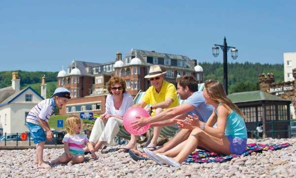 Victoria Hotel Family Sitting on Beach with Hotel in Background
