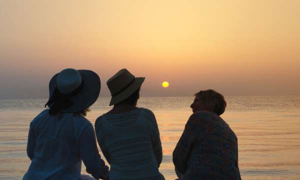 Group of friends looking out to sea at sunset