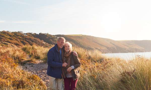 A mature couple taking a walk on a beach path in winter
