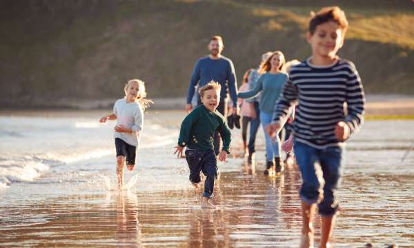 A large family walking and running along the beach