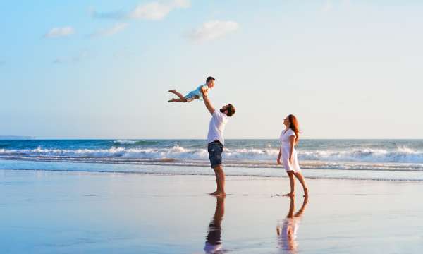 Family walking along a beach having fun