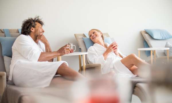 Couple in source spa drinking herbal tea