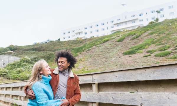 couple walking down from saunton sands hotel beach