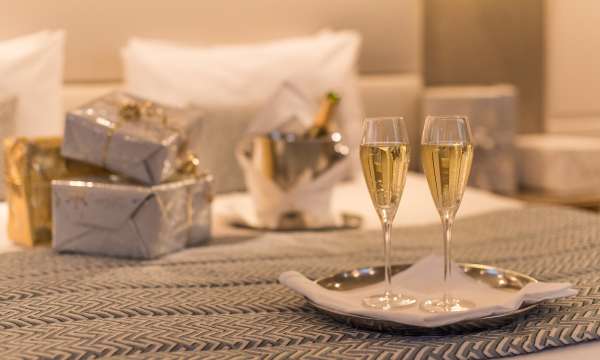 christmas presents and champagne on bed at Carlyon Bay Hotel