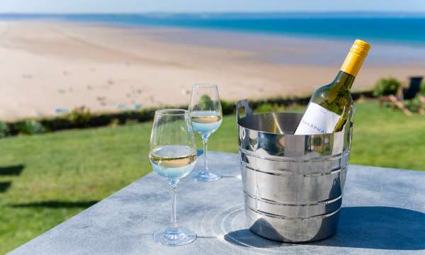 Bottle of chilled Sharpham Wine with two glasses alfresco 