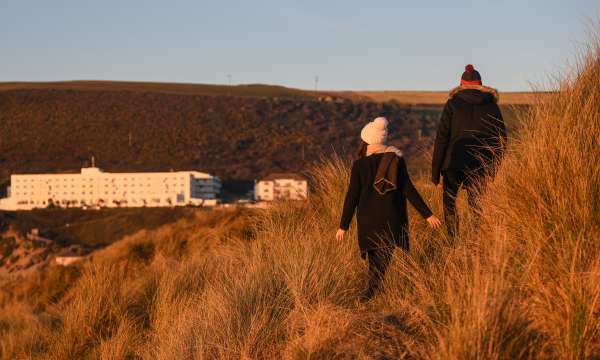 Couple walking down the dunes during winter