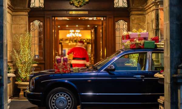 Rolls Royce Parked at Entrance and Santa Walking into the Victoria Hotel with Gifts