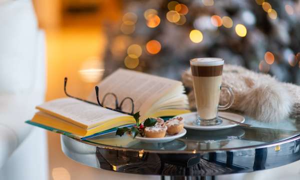 Late, book and mince pies with Christmas tree in background