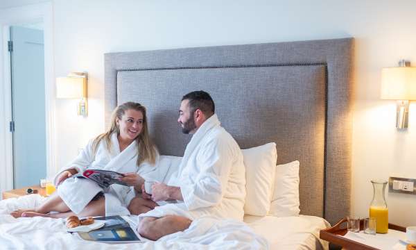 Couple in bed having breakfast