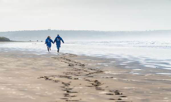 Couple walking along Saunton Sands