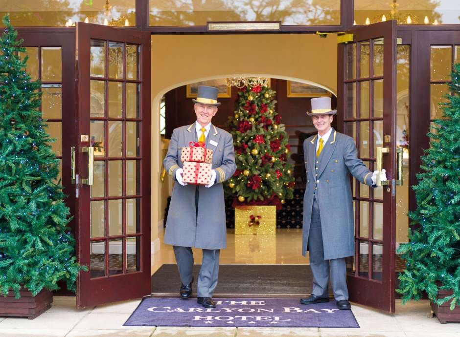 Carlyon Bay Hotel Doorman Carrying Christmas Presents at Hotel Entrance