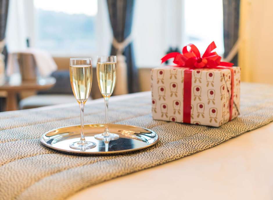 Royal Duchy Hotel Christmas Present and Flutes of Champagne on Bed in Room