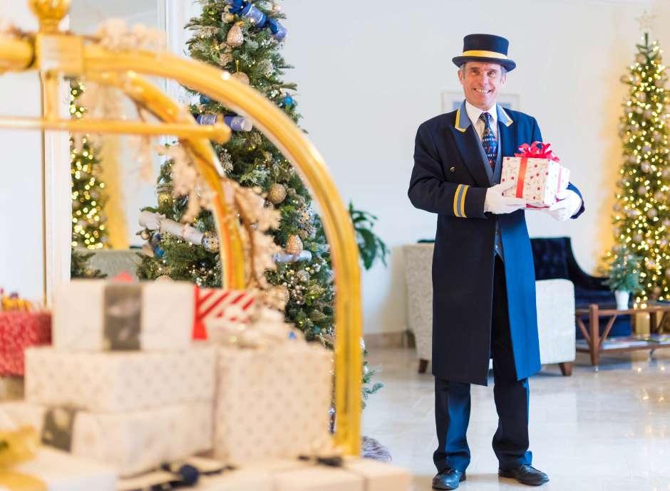 Royal Duchy Hotel Doorman with Presents by Christmas Tree
