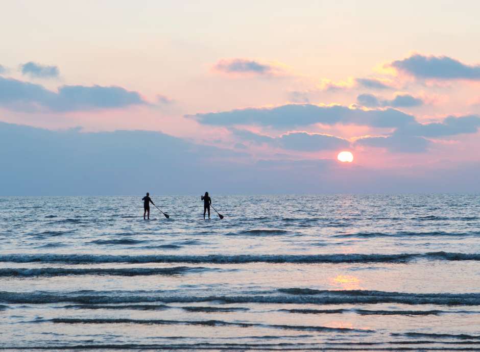 Two paddle boarders in the winter