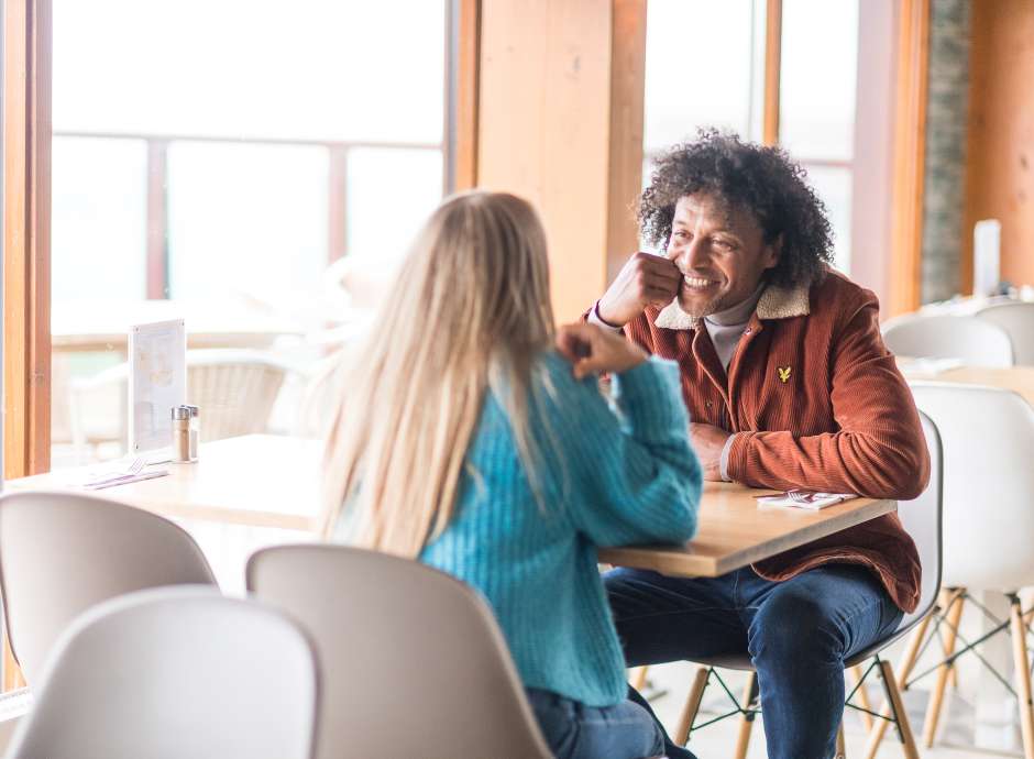 couple sat at table in beachside grill man smiling at woman