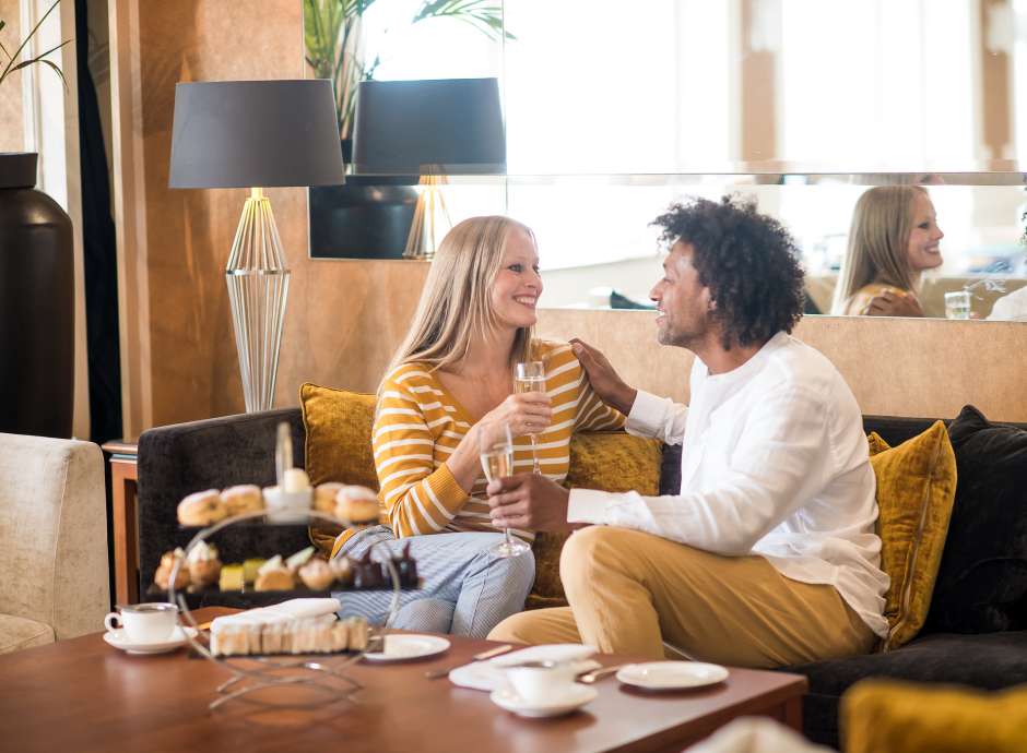 Saunton Sands couple sat on sofa in lounge with afternoon tea