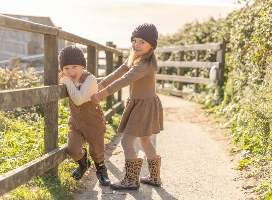 Two young children walking down the path to the beach 